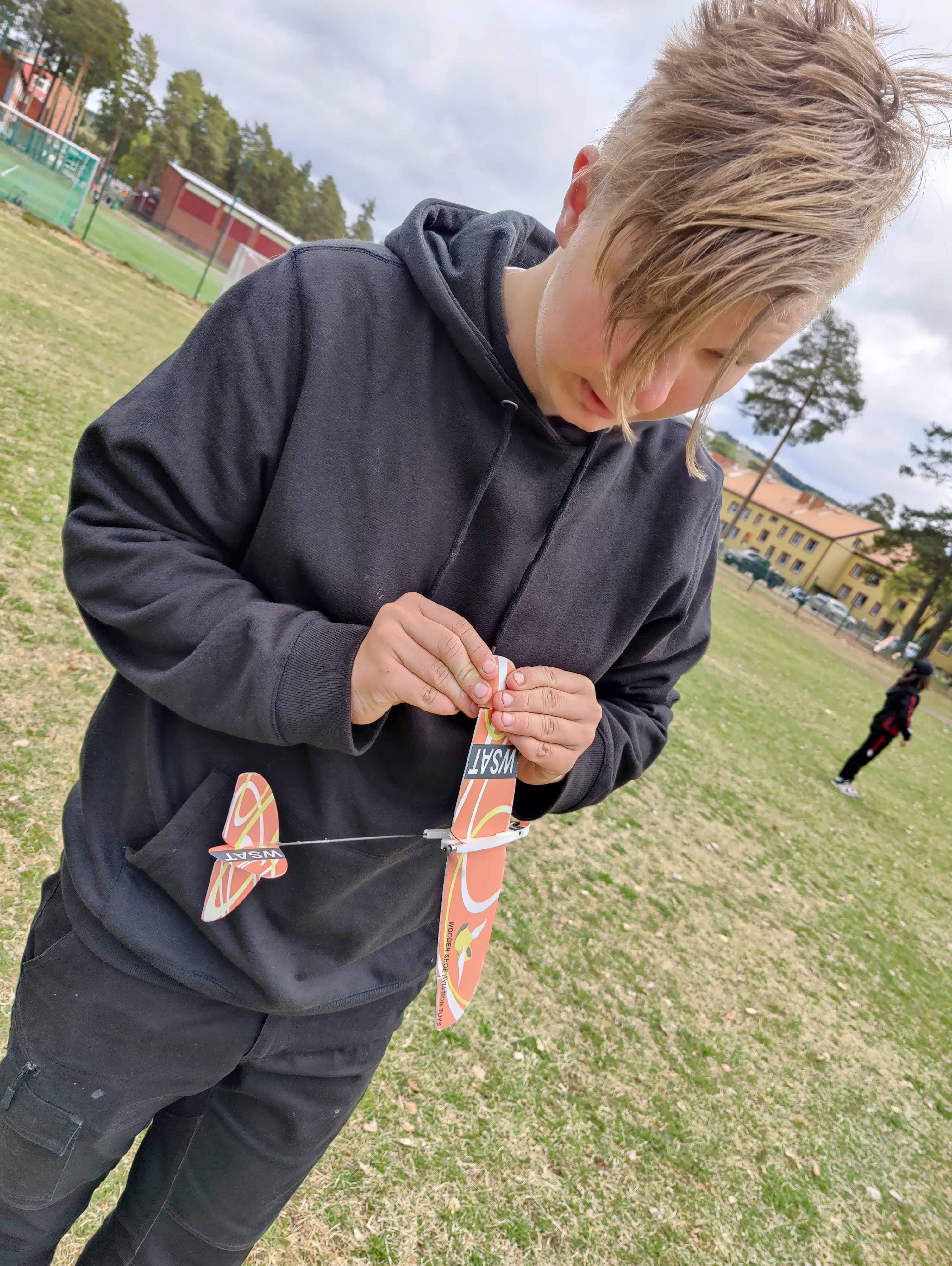 Anton från Modellflygklubben Fenix i Rättvik hjälper till med intrimning under Rättviksskolans flygdag. Foto: Emmy Ihlar, Dalabygden.